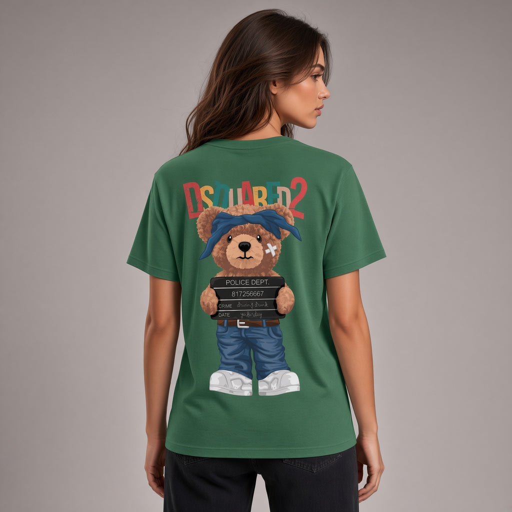 A woman shown from the back wearing a green short-sleeve T-shirt with a large cartoon teddy bear graphic and colorful 'DSU WORLD 2' text on the back, against a plain gray studio background.