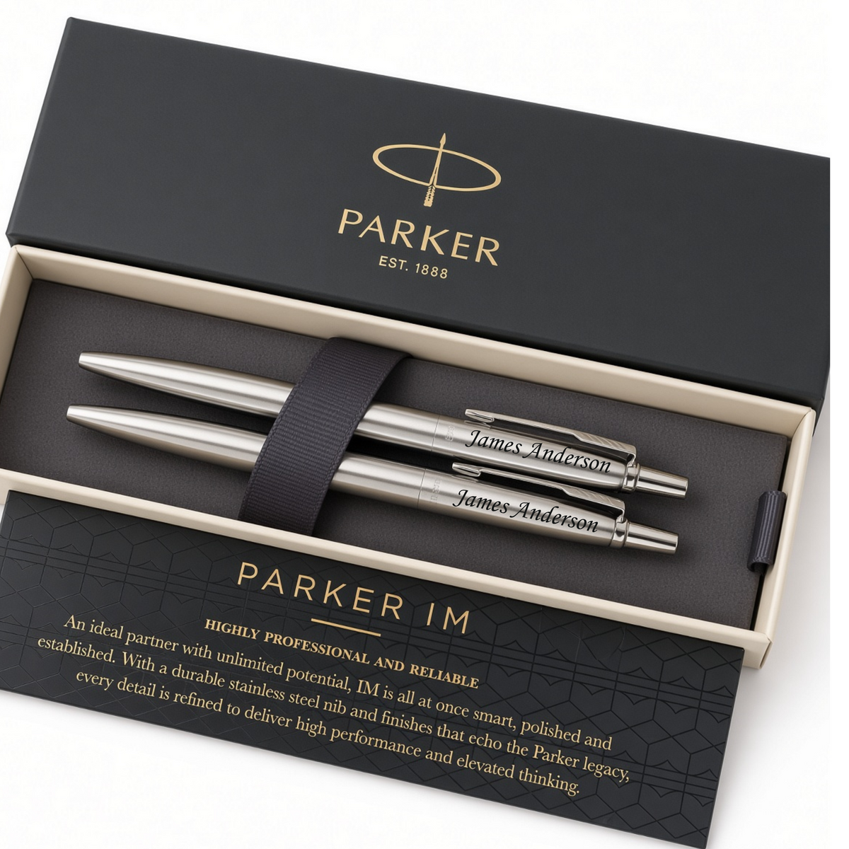 A Parker IM pen set in an open black presentation box, featuring two silver metal pens secured by a black ribbon and branded packaging with gold lettering.
