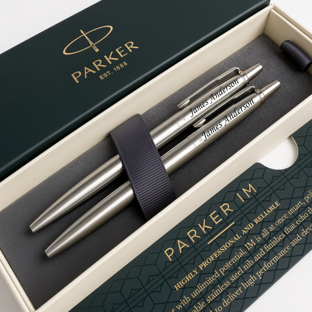 Three Parker ballpoint pens in a sleek silver finish, presented inside an open cream-colored gift box with dark green branded packaging. The pens are secured by a dark navy elastic band, and the brand name 'PARKER' is clearly visible on both the pen barrels and the box lid.
