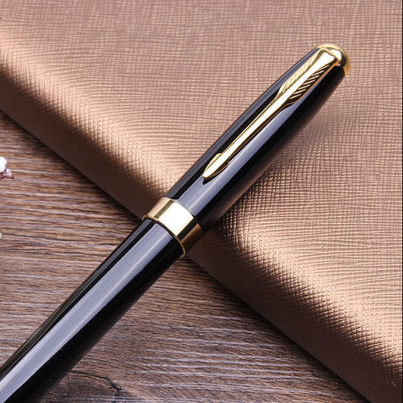 A glossy black fountain pen with gold trim and a gold clip, placed diagonally on a brown textured surface with white flowers in the corner. The brand name 'XIER' is visible in the top left.