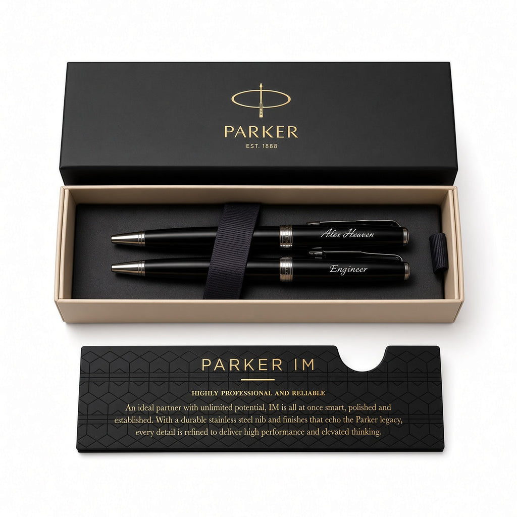 Parker IM pen set in a black presentation box with a black presentation card, photographed on a clean white background. The set includes two black pens with silver and gold accents, a black ribbon, and branded packaging.