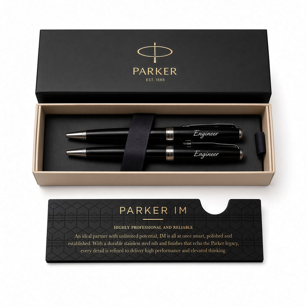 Parker IM pen set in a black presentation box with a matching black card, photographed on a clean white background. The set includes two black pens with silver and gold accents, a black ribbon, and branded packaging.