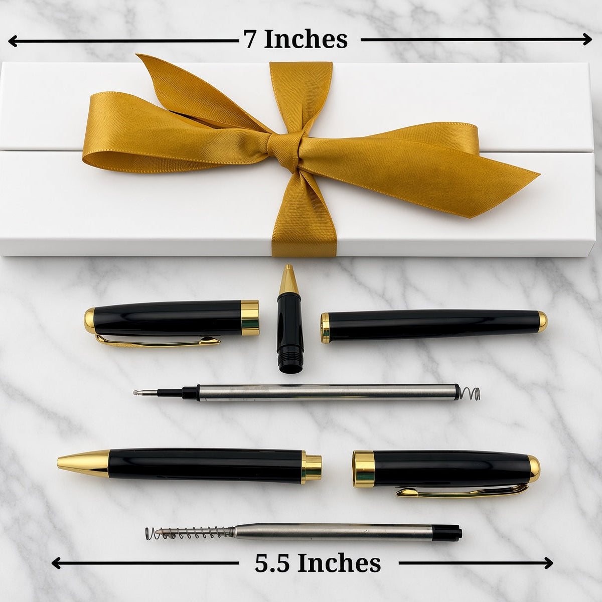 A pen set arranged on a white marble surface with a white gift box tied in gold ribbon behind it. Arrows and text show dimensions: 7 inches across the box and 5.